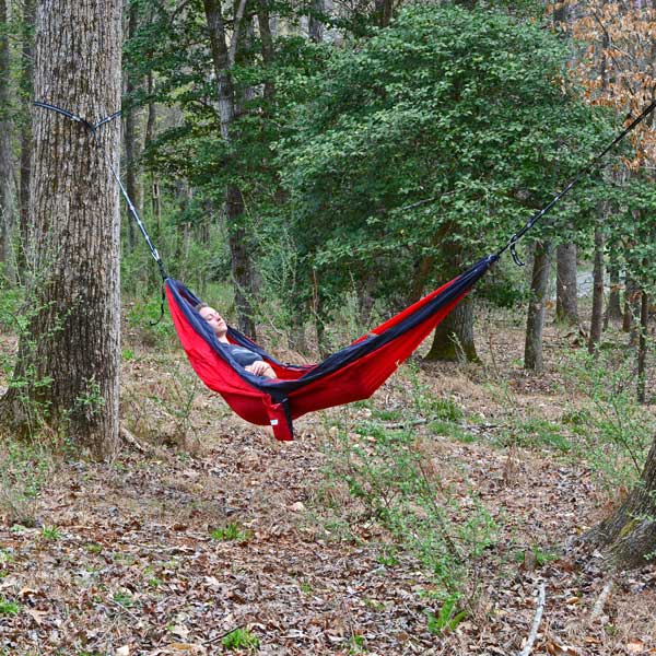 Women Relaxing in Woods on Red Hammock