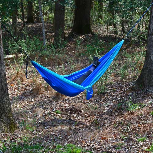Women Relaxing in Woods on Blue Hammock