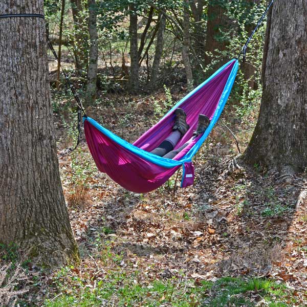 Bright Purple and Blue GO2 Traveler Nylon Hammock with Women Relaxing in Woods