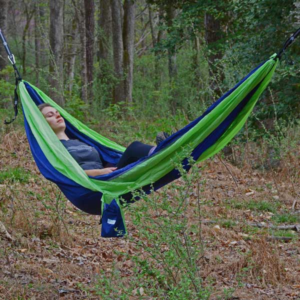 Women Relaxing on Lime Green and Blue Hammock in Woods